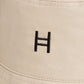 Beige cap with a black logo on a beige background 