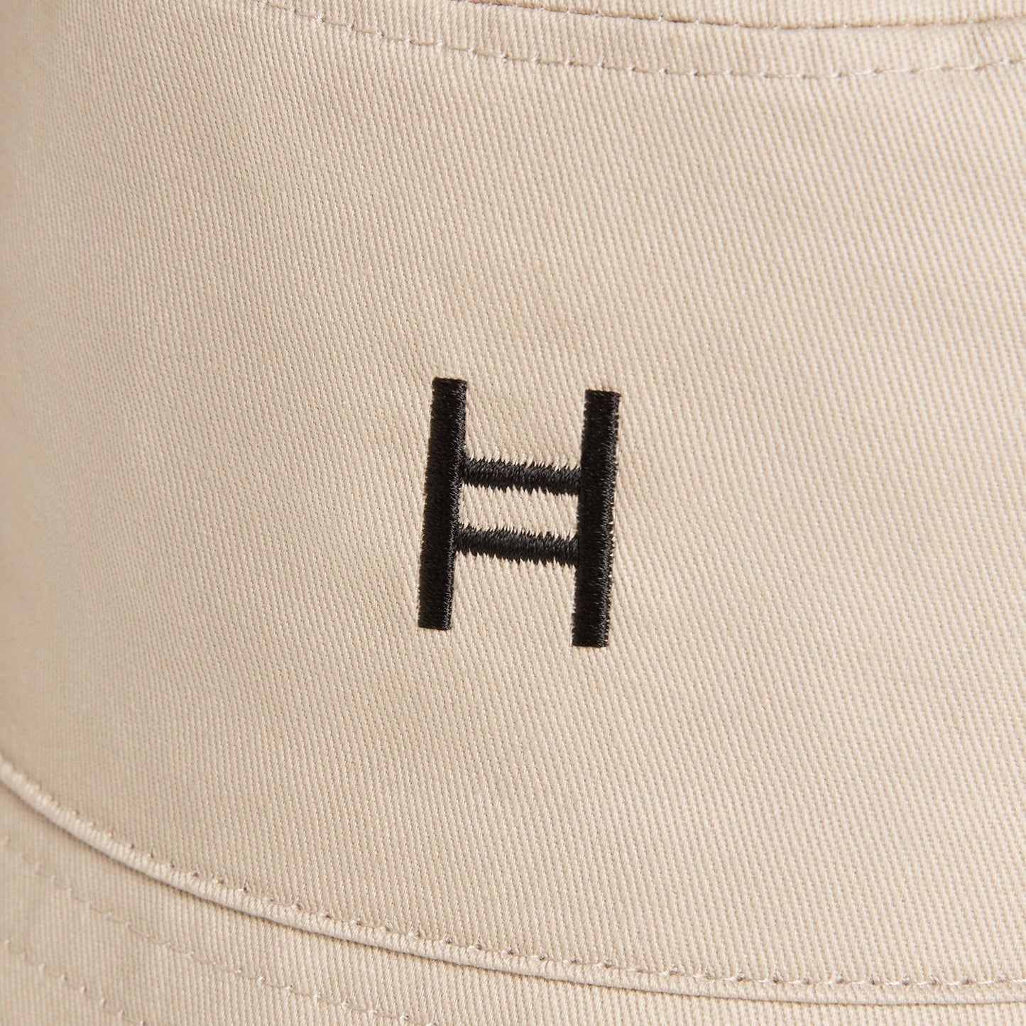 Beige cap with a black logo on a beige background 