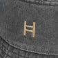 Close-up of a dark gray fabric surface with a gold logo. 